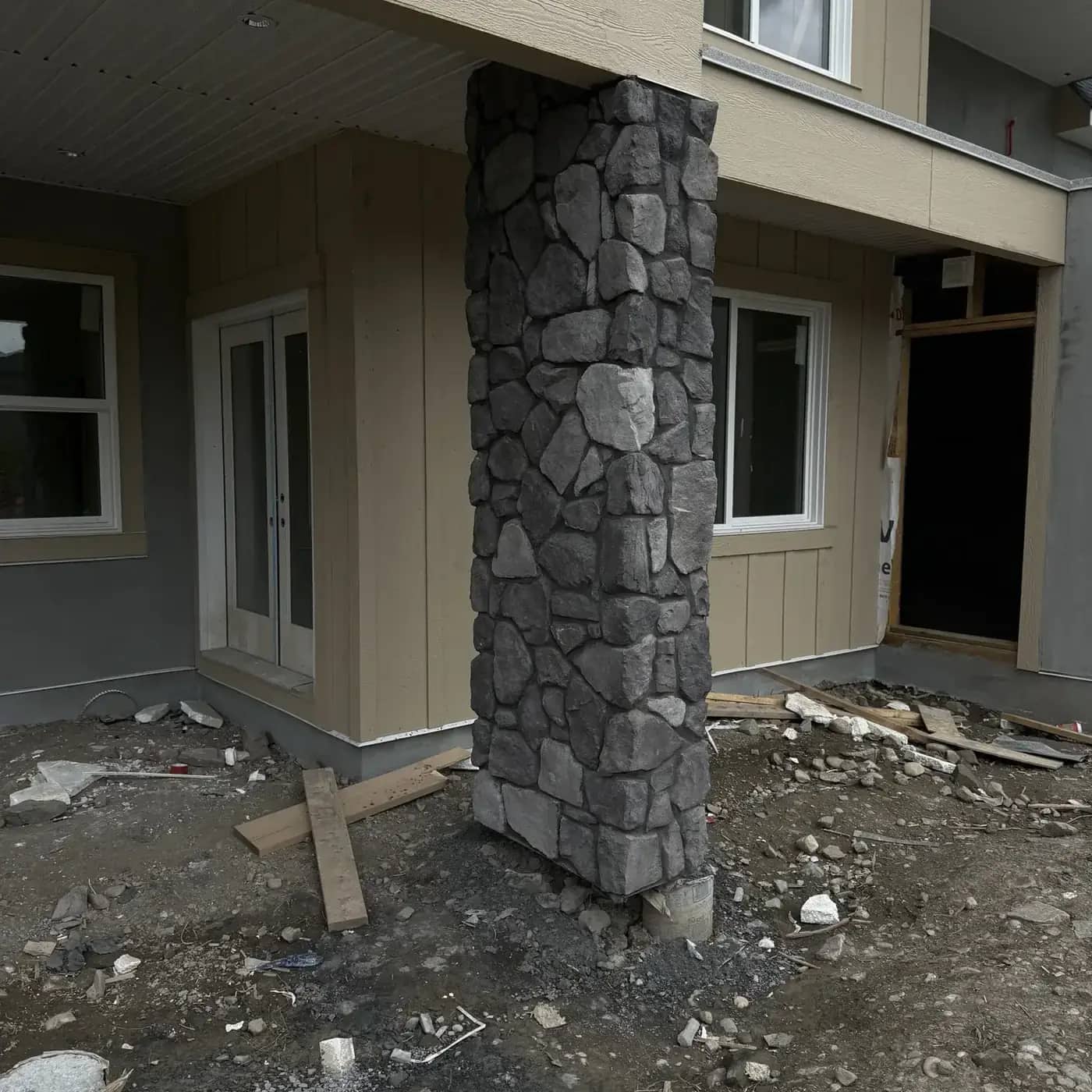 Dark rugged stone column under a covered backyard outdoor area
