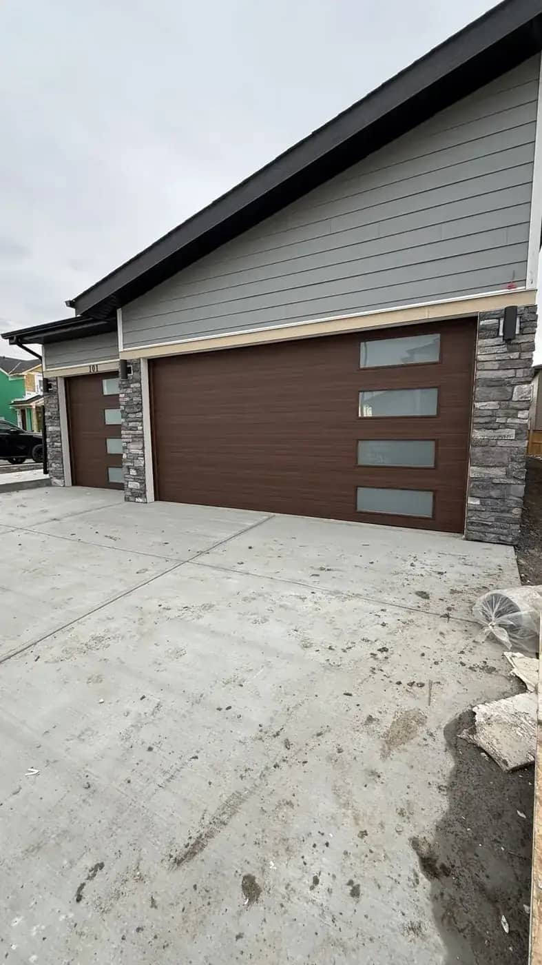 Rustic grey stone entry column beside siding and concrete edge