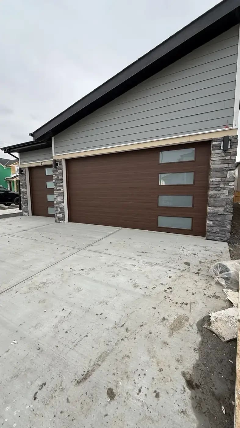 Garage apron and concrete flatwork connected to stone garage pillars