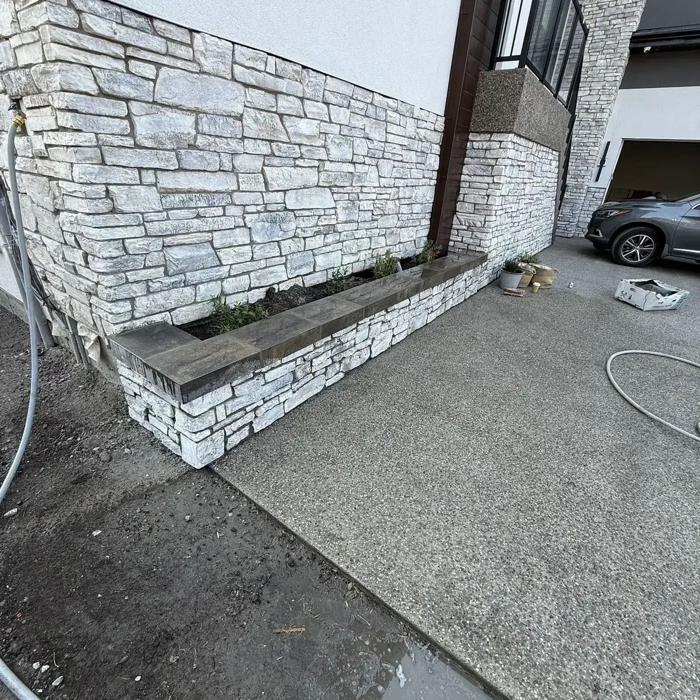 White stone retaining planter wall and concrete exterior surface
