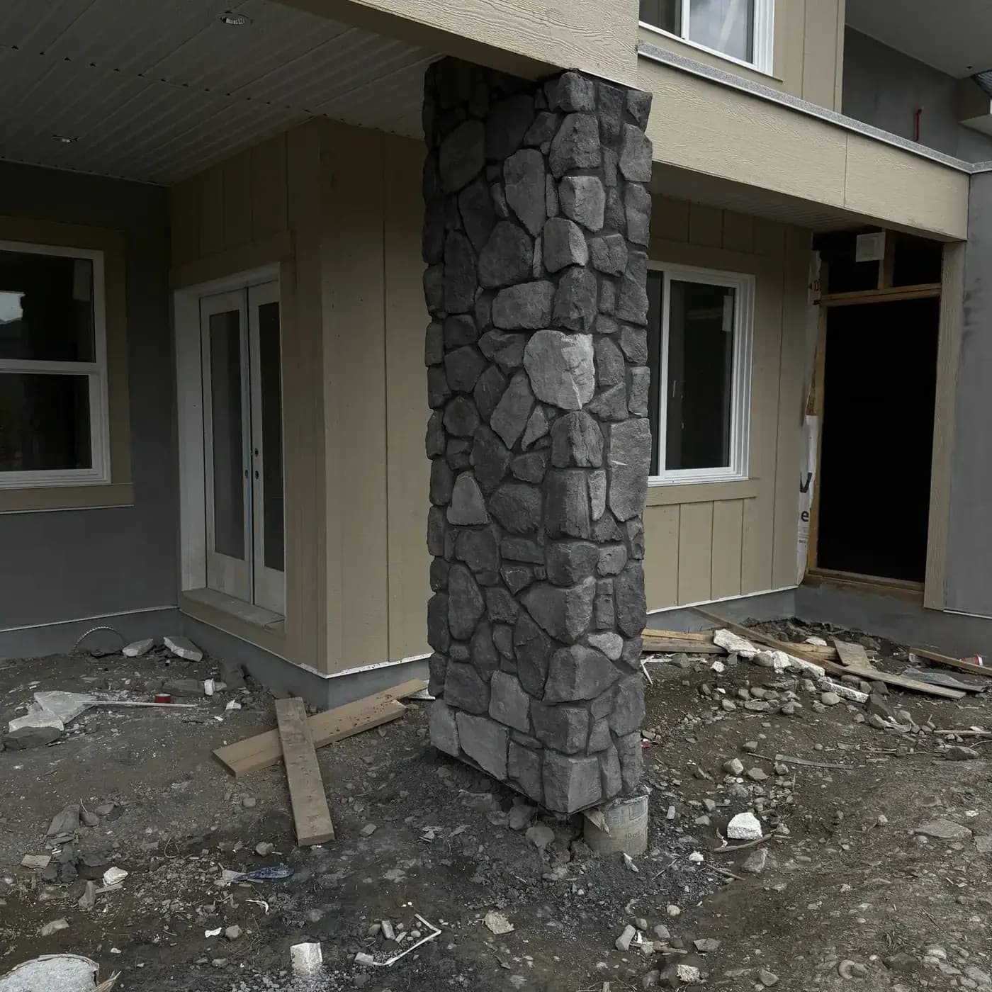 Dark rugged stone column under a covered backyard outdoor area