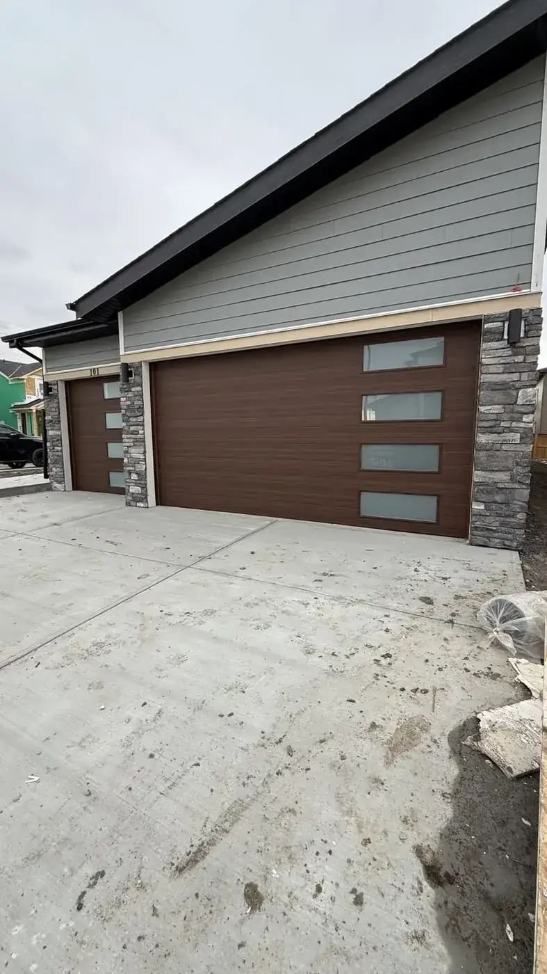 Rustic grey stone entry column beside siding and concrete edge