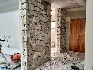 Exterior stone feature wall with vertical masonry face and surrounding entry details