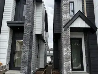 Modern residential exterior with grey stone veneer columns and entry facade